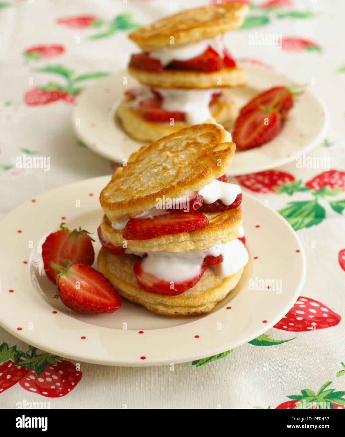 Stapel von dicken Pfannkuchen mit Erdbeeren und Sahne Stockfoto