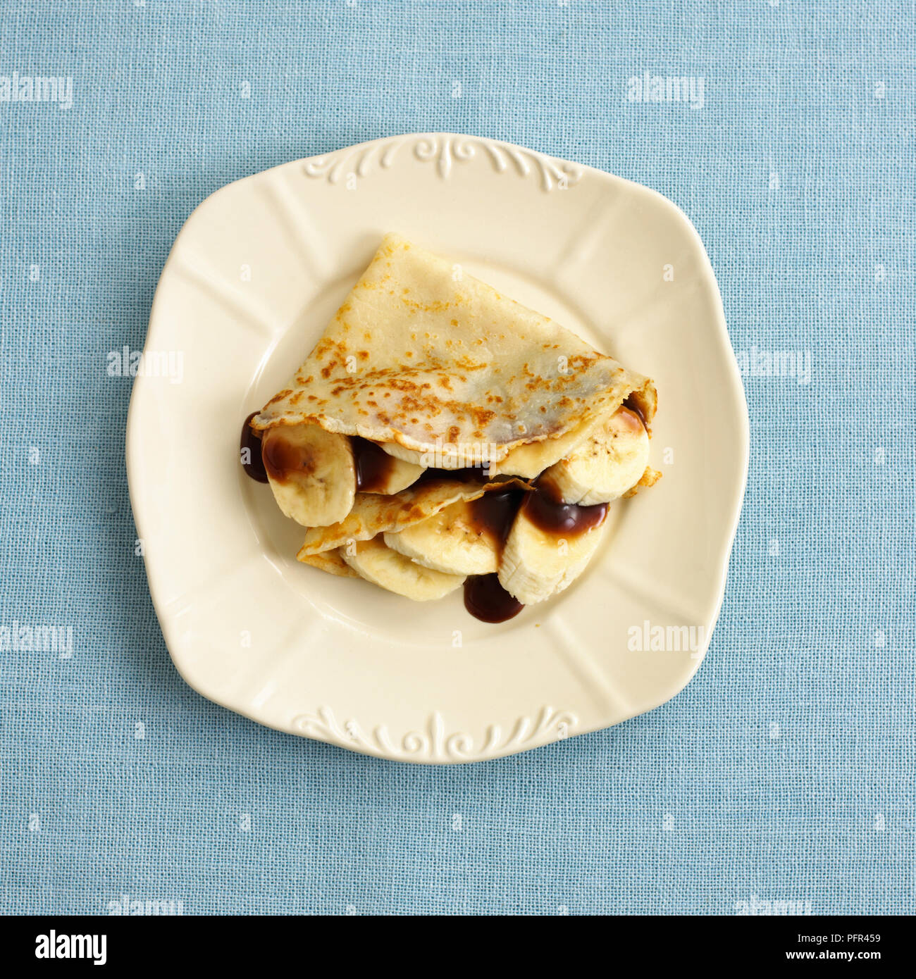 Gefaltete Pfannkuchen mit Banane und Schokosauce Stockfoto