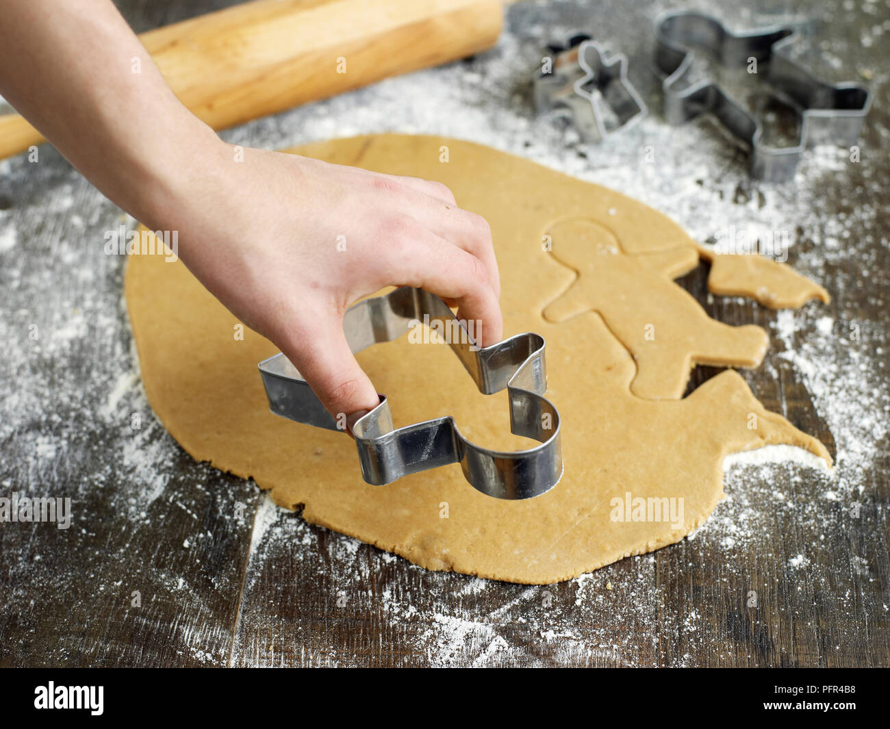 Verwendung Cookie Cutter menschlichen Formen auf Lebkuchen Teig zu schneiden Stockfoto