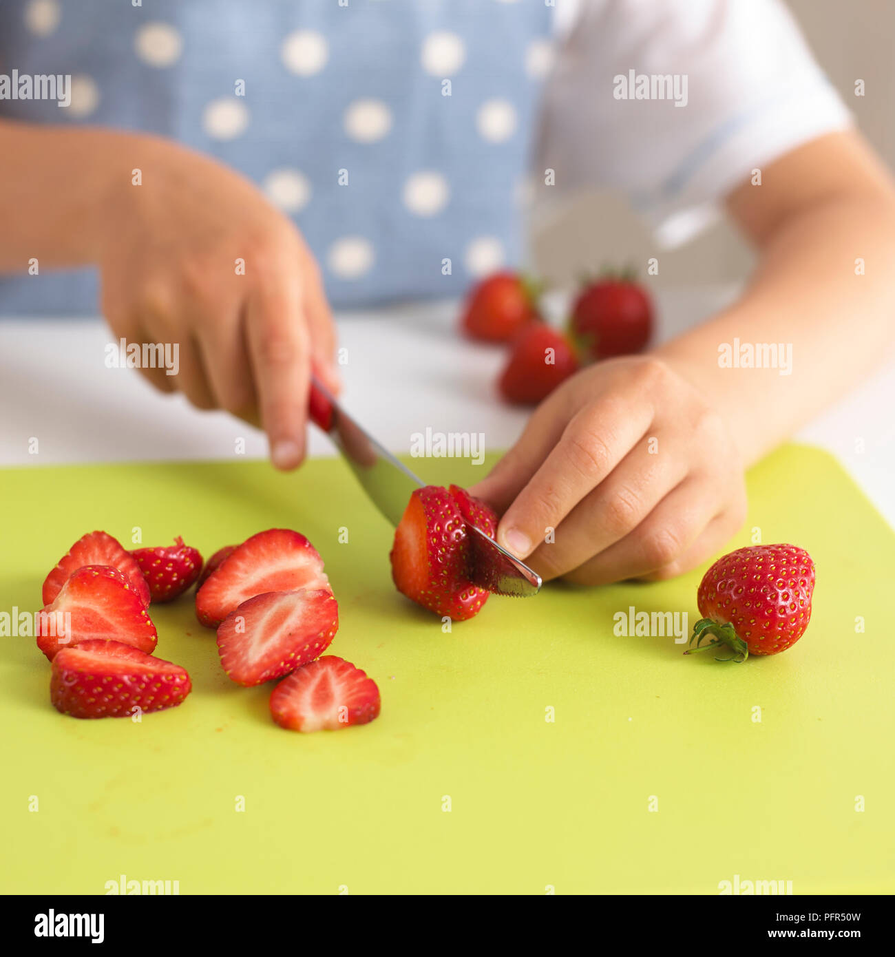 Kind schneiden Erdbeeren Stockfoto