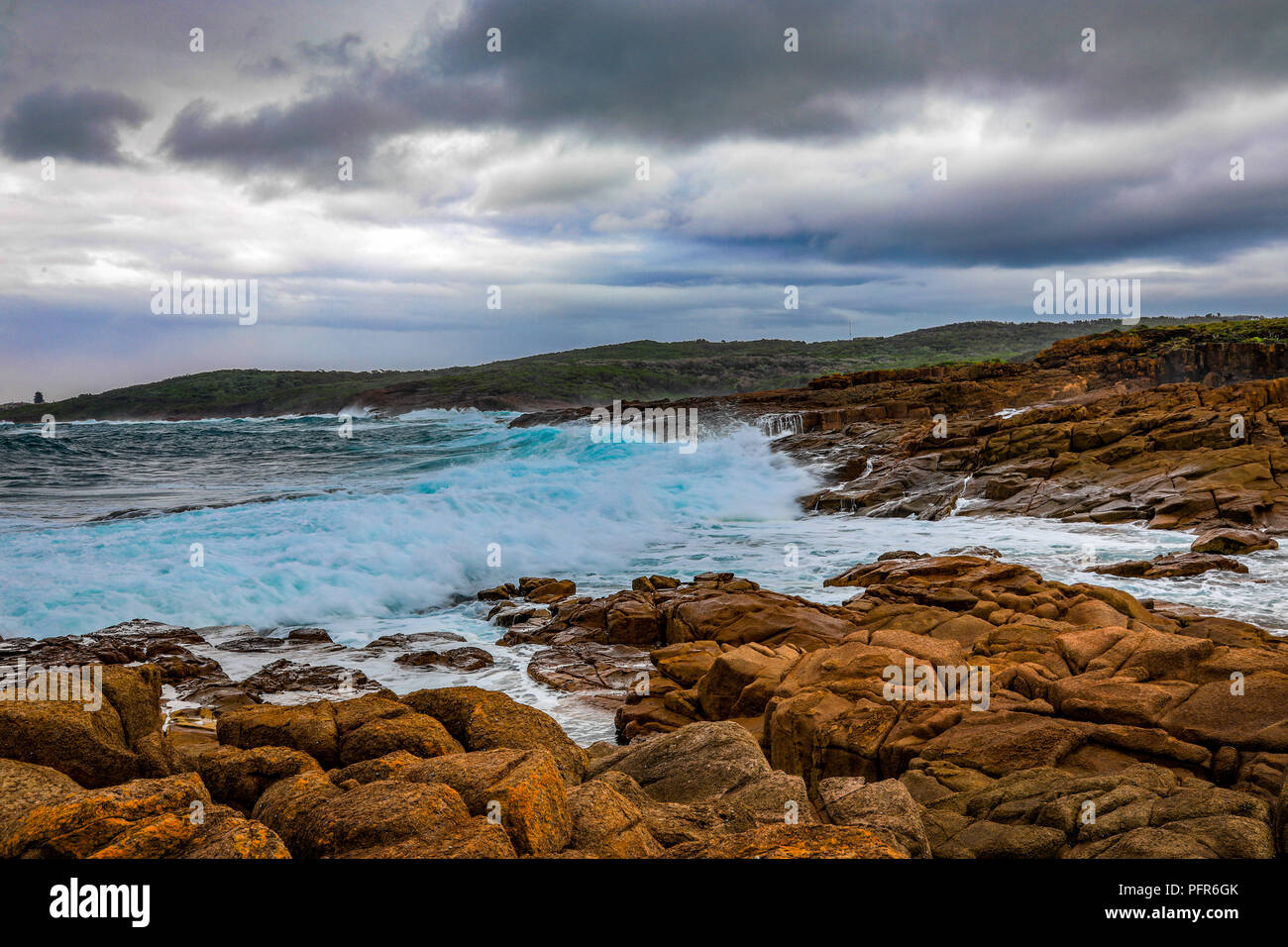 Sonnenaufgang über dem Meer und dem Strand unter bewölktem Himmel Stockfoto