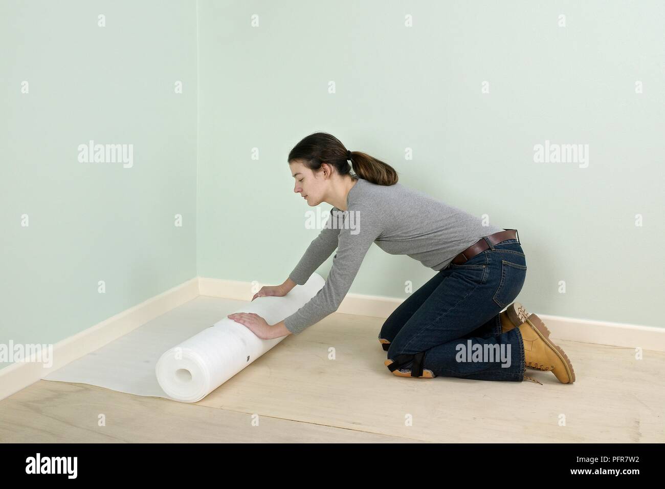 Frau Roll-out Unterlage auf Holzboden Stockfoto