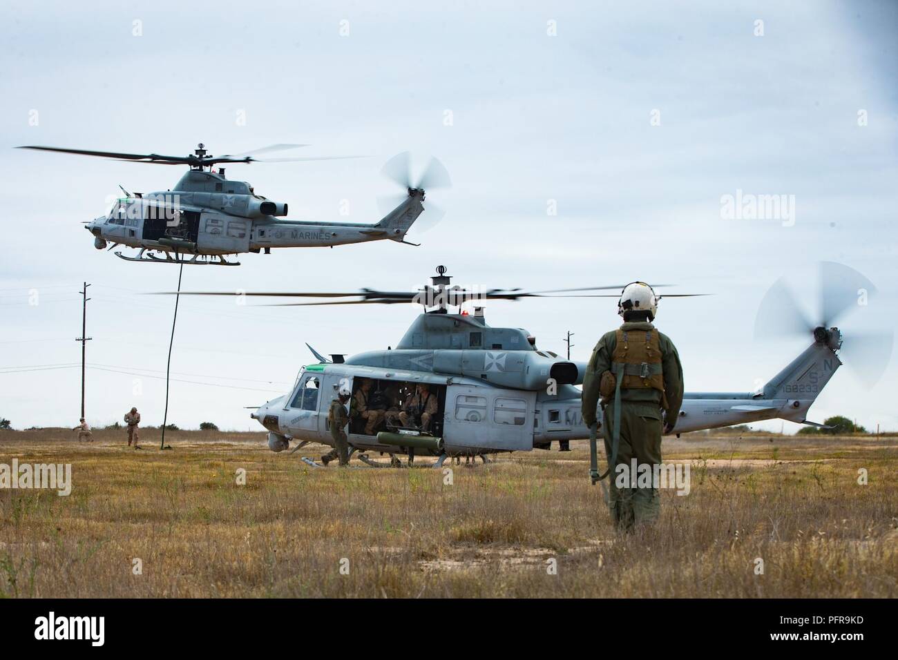 Ein US-Marine UH-1Y Venom Crew Chief mit Marine Light Attack Helicopter Squadron 169, Marine Flugzeuge Gruppe 39, 3. Marine Air Wing, geht zurück zu seinem Hubschrauber während einer Übung des fastrope Marine Corps Base Camp Pendleton, Calif., 22. Mai 2018. Das Training wurde von 1 Light Armored Reconnaissance Bataillon, die von den 1st Light Armored Reconnaissance Bataillon in Verbindung mit 1 Air Naval Geschützfeuer Liaison Firma durchgeführt, die gute Kenntnisse in Mission Skills und Corporation mit Schwester Bataillone zu erhöhen. Stockfoto