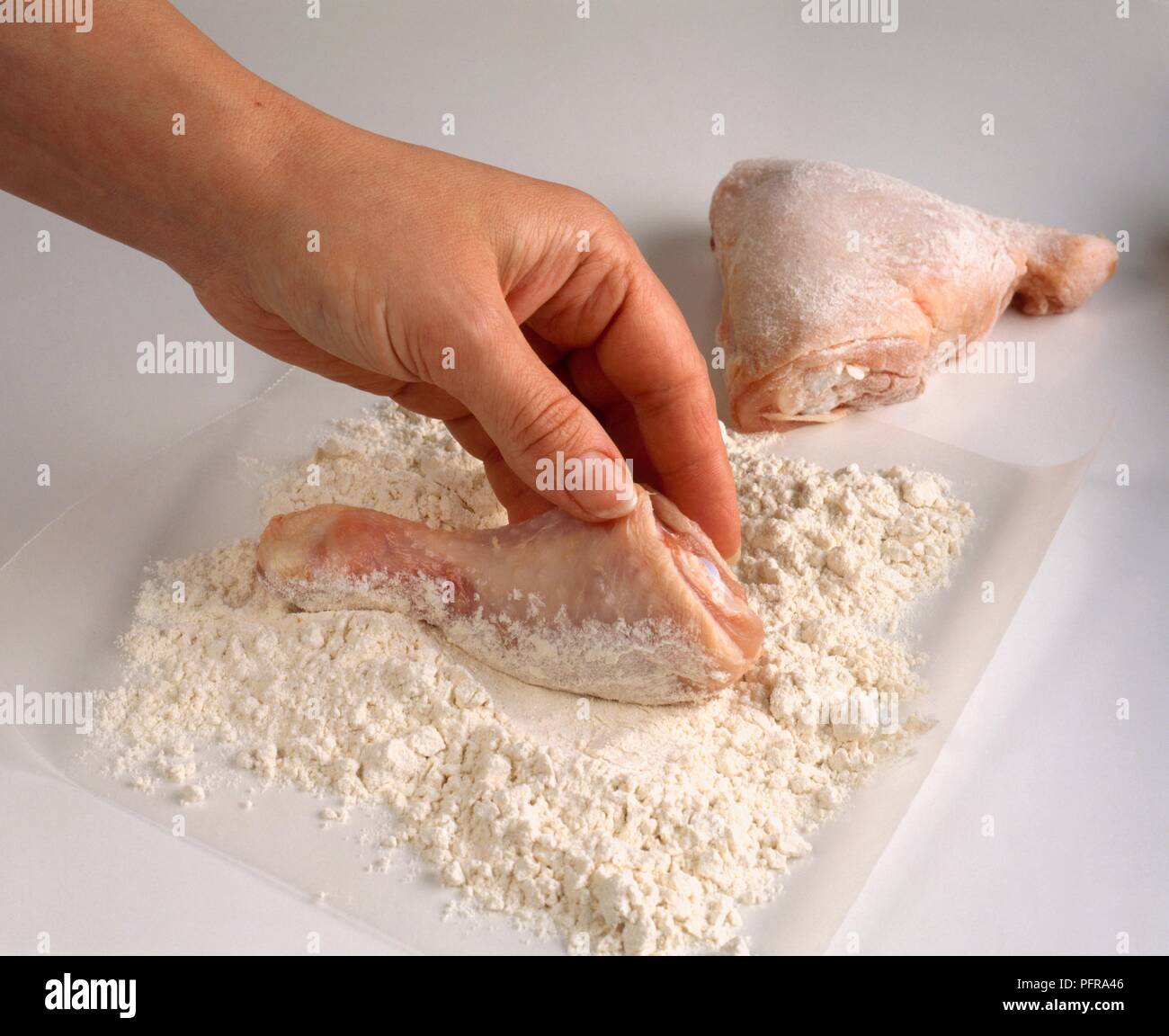 Mit Händen Hühnerteile in Mehl zu decken Stockfoto