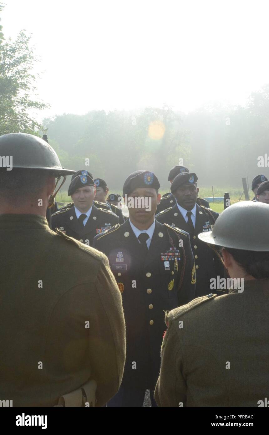 Sgt. 1. Klasse Maurice Smith, 1 Infanterie Division, ein Eingeborener von Philadelphia, Pennsylvania, steht vor seiner Ausbildung, durch Mitglieder der Kommandierende General montiert Color Guard flankiert, 1. Inf. Div., vor der 1-ID Denkmal rededication Zeremonie in Cantigny, Frankreich, 26. Mai 2018. Mitglieder der CGMCG trug der Erste Weltkrieg Ära "doughboy "Uniformen für die Zeremonie, die auch das hundertjährige der WWI Schlacht von Cantigny gekennzeichnet. Stockfoto