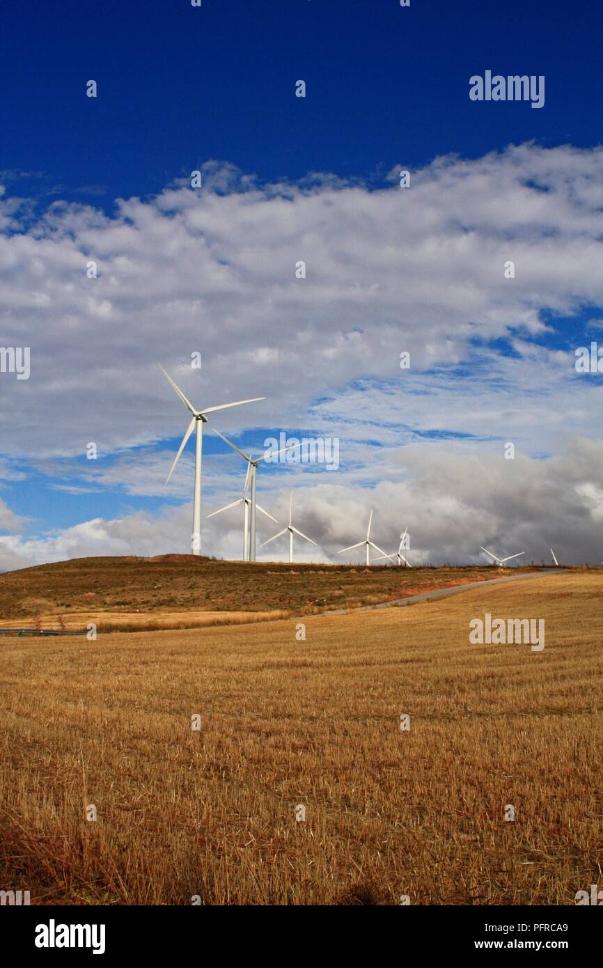 Spanien, Windenergieanlagen auf Ebenen mit blauem Himmel und weißen Wolken über Stockfoto