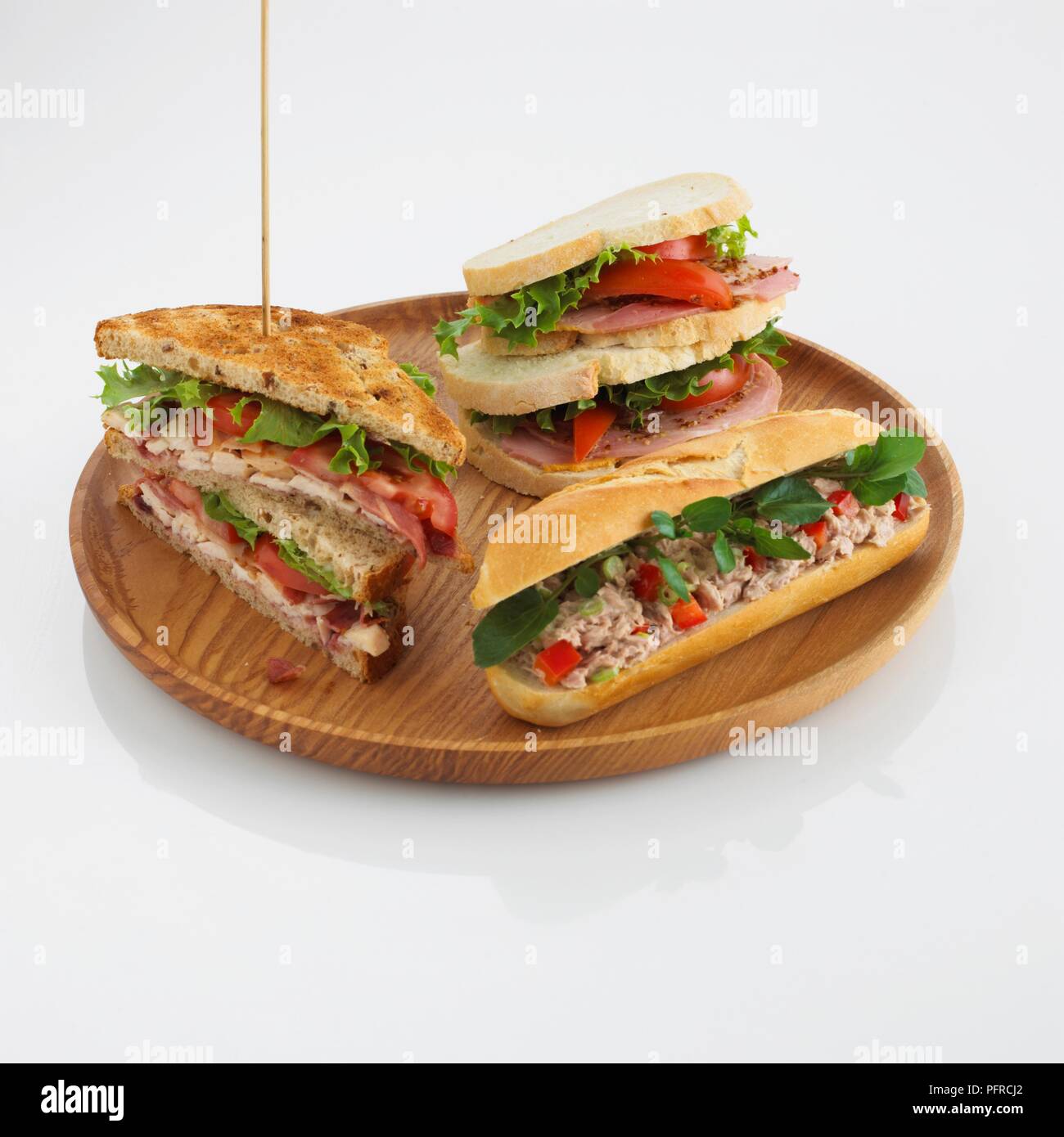 Getoastetes Sandwich, Club Sandwich und Thunfisch salat Brötchen auf Holzplatte Stockfoto