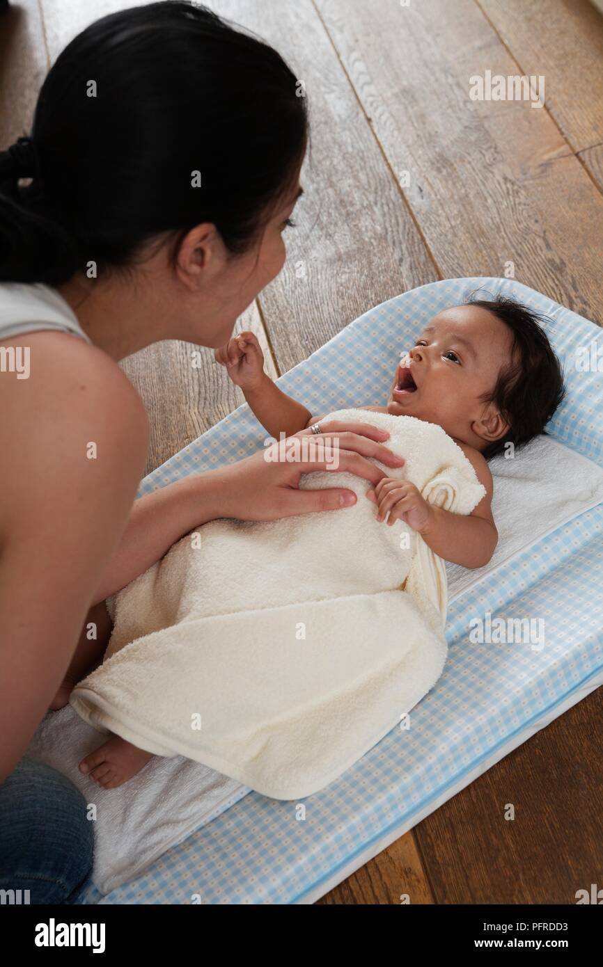Baby Junge lag auf dem Rücken auf eine Wickelauflage, mit einem Tuch bedeckt sein. Stockfoto