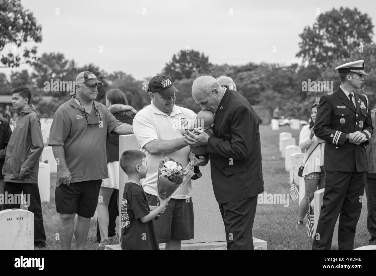 Chef des Stabes John Kelly (rechts) küsst den Kopf des Kindes eines Besuchers in Abschnitt 60 von Arlington National Cemetery, Arlington, Virginia, 28. Mai 2018. Nach dem Memorial Day Einhaltung am Denkmal Amphitheater, Kelly kam zu Abschnitt 60 mit seiner Frau, Karen Hernest Kelly, die Grabstätte ihres Sohnes zu besuchen, US Marine Corps 1. Lt Robert Michael Kelly. Stabschef Kelly sprach auch mit anderen Besuchern, Freunden und Familienangehörigen besuchen Grabstätten in Abschnitt 60. Stockfoto