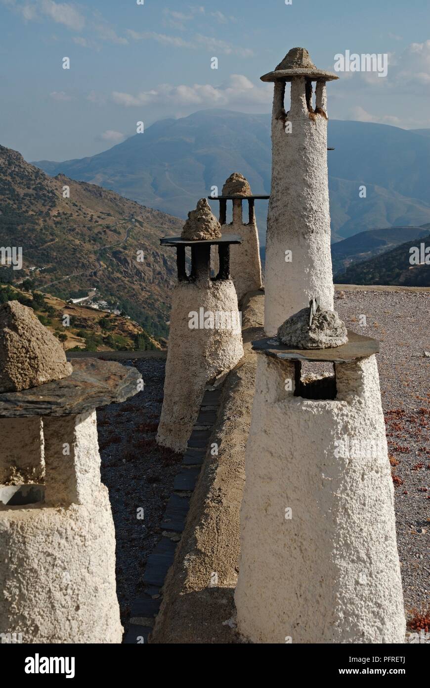 Spanien, Andalusien, Capileira, hohe weiße Schornsteine auf einem flachen Dach in Bergdorf Stockfoto