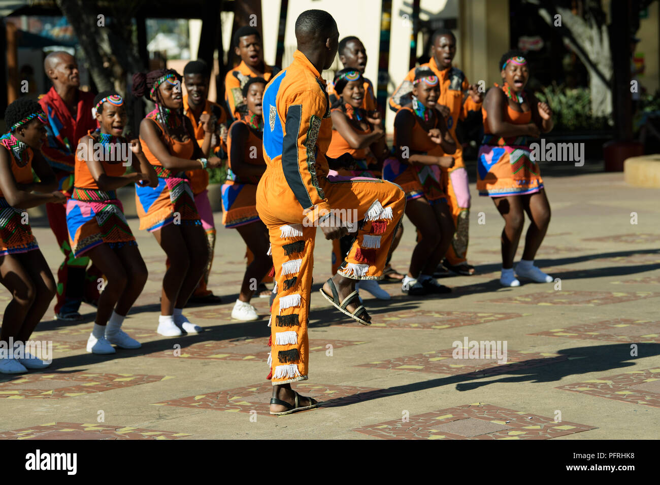 Hohe Stepping in Zulu traditionelle Kleidung der führenden Gruppe junger Straßenkünstler unter zeigen Touristen zu unterhalten, Durban, KwaZulu-Natal, ZAR Stockfoto