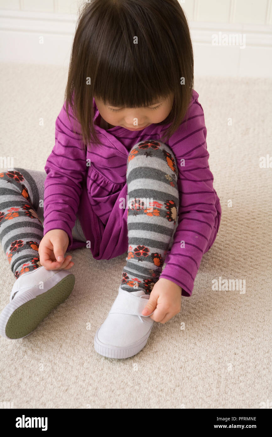 Mädchen Befestigungsband am Shoe Stockfoto