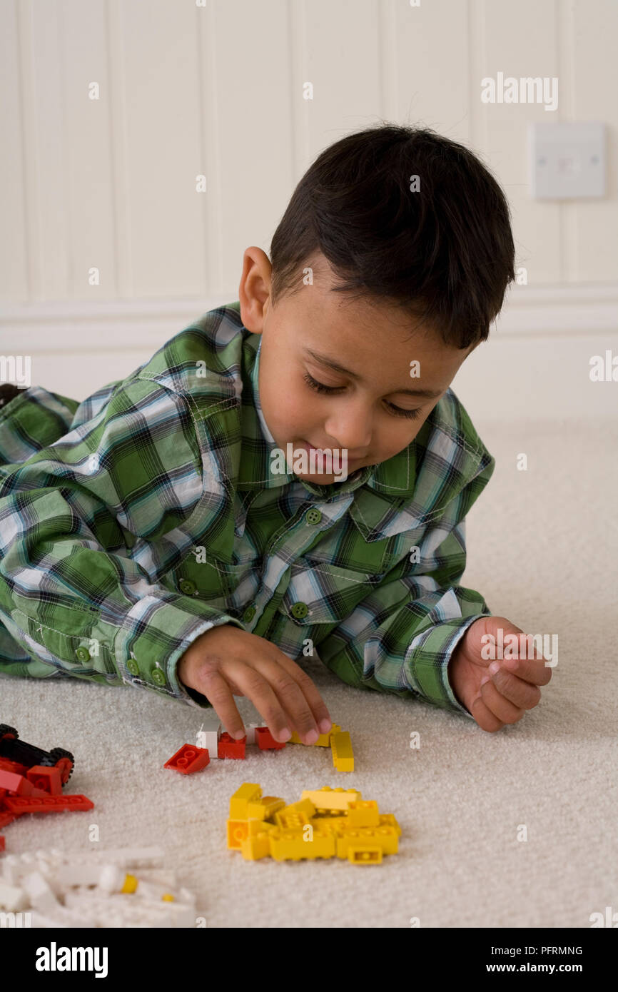 Junge spielt mit Kunststoff Ziegel Spielzeug Stockfoto