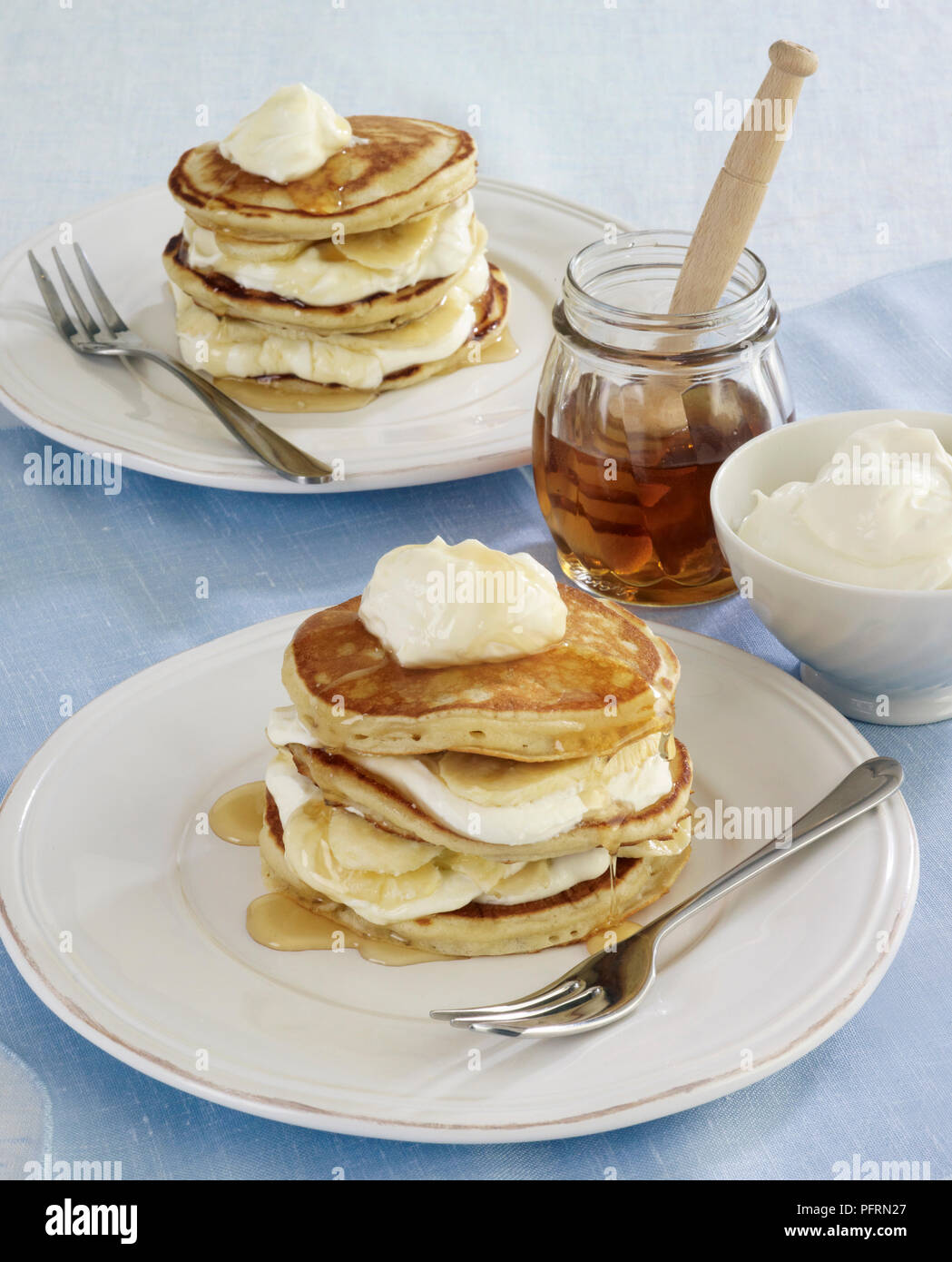 Amerikanische Pfannkuchen Stack mit Joghurt, Bananen und Honig gefüllt Stockfoto