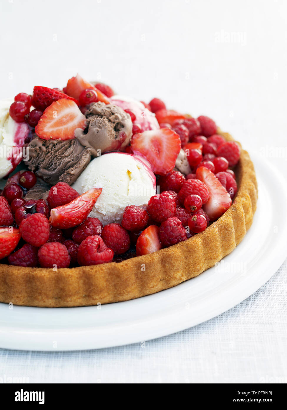 Mixed berry Flan mit Eis serviert auf weiße Platte, close-up Stockfoto