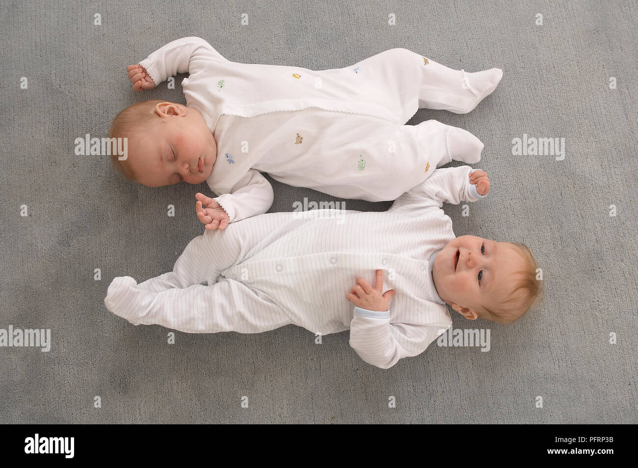 Twin Baby Jungen tragen babygros lag auf dem Rücken auf dem Teppich, Ansicht von oben, 17 Wochen Stockfoto