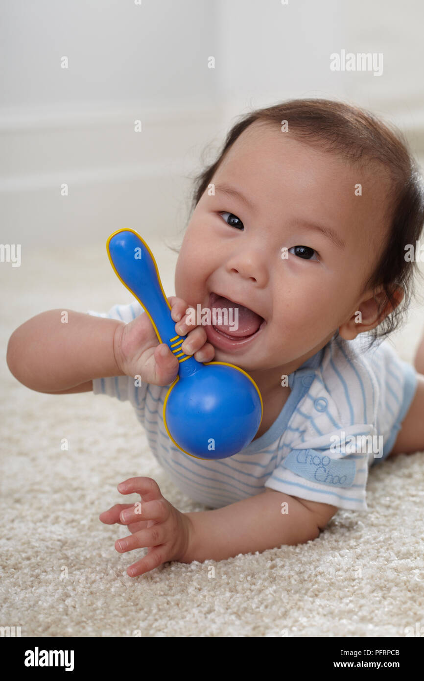 Baby Boy (6 Monate) Holding Kunststoff rattle Stockfoto