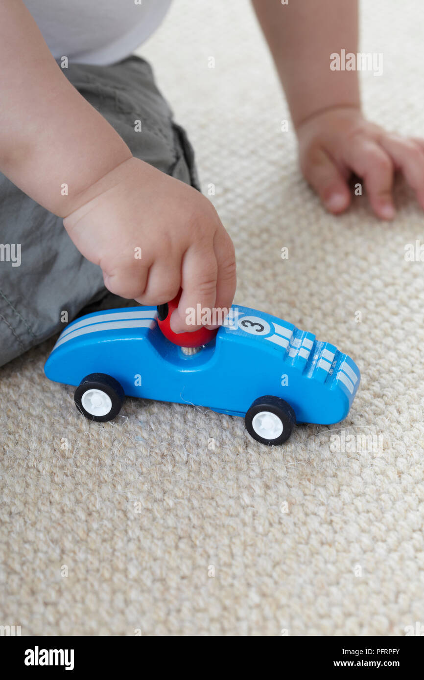 Baby Junge spielt mit Blue Spielzeugauto Stockfoto