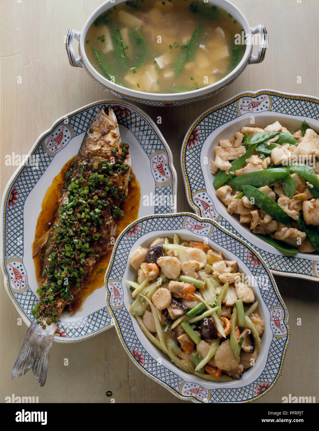 Tofu Suppe mit Fischbestand, geschmorter Fisch Hunan-Szechwan-Stil, gebratenen Jakobsmuscheln in Austernsauce, und Rühren - Gebratenes Fischfilet auf Platte Stockfoto