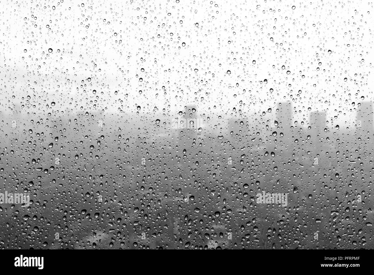 Schwarze und weiße Regen fällt auf ein Fenster Stockfoto