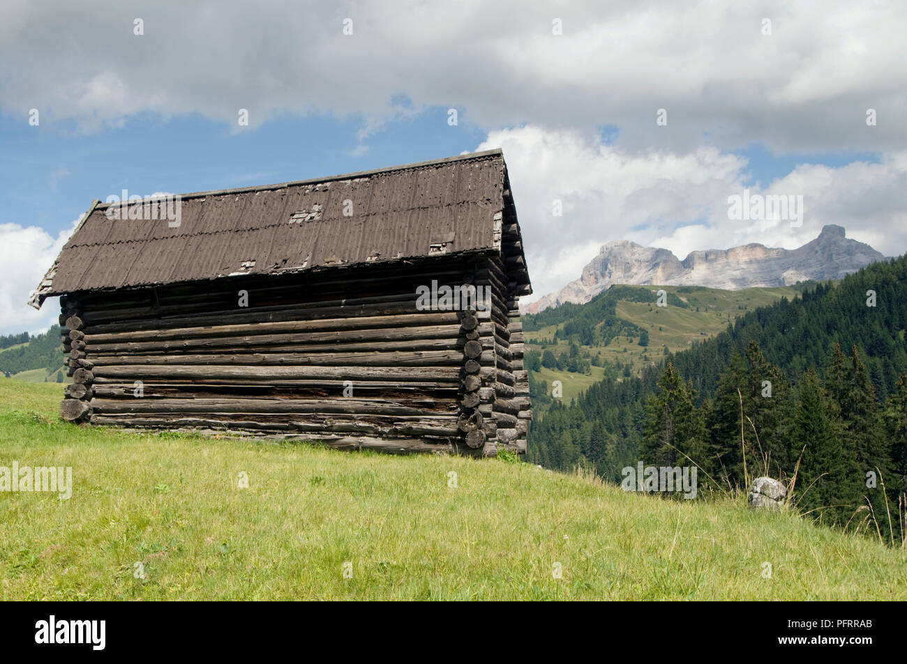 Italien, Trentino Alto Adige, Val Badia, St Leonard, Holz- Bauernhaus mit Blick auf die Berge im Hintergrund Stockfoto