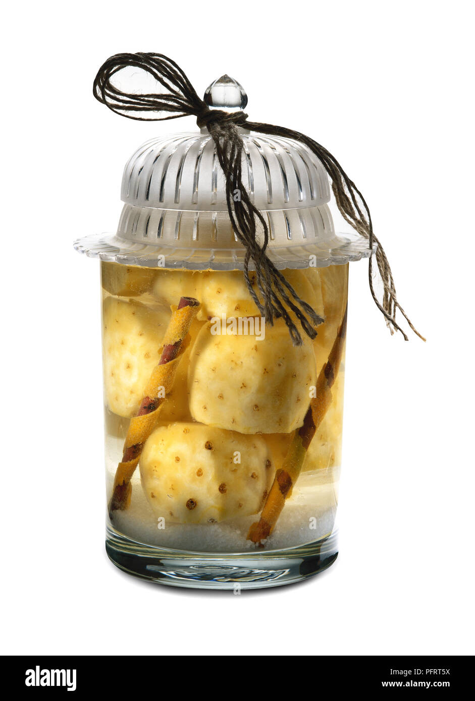 Glas mit Stücken von Ananas in Kirschwasser bewahrt und mit Zimtstangen aromatisiert Stockfoto