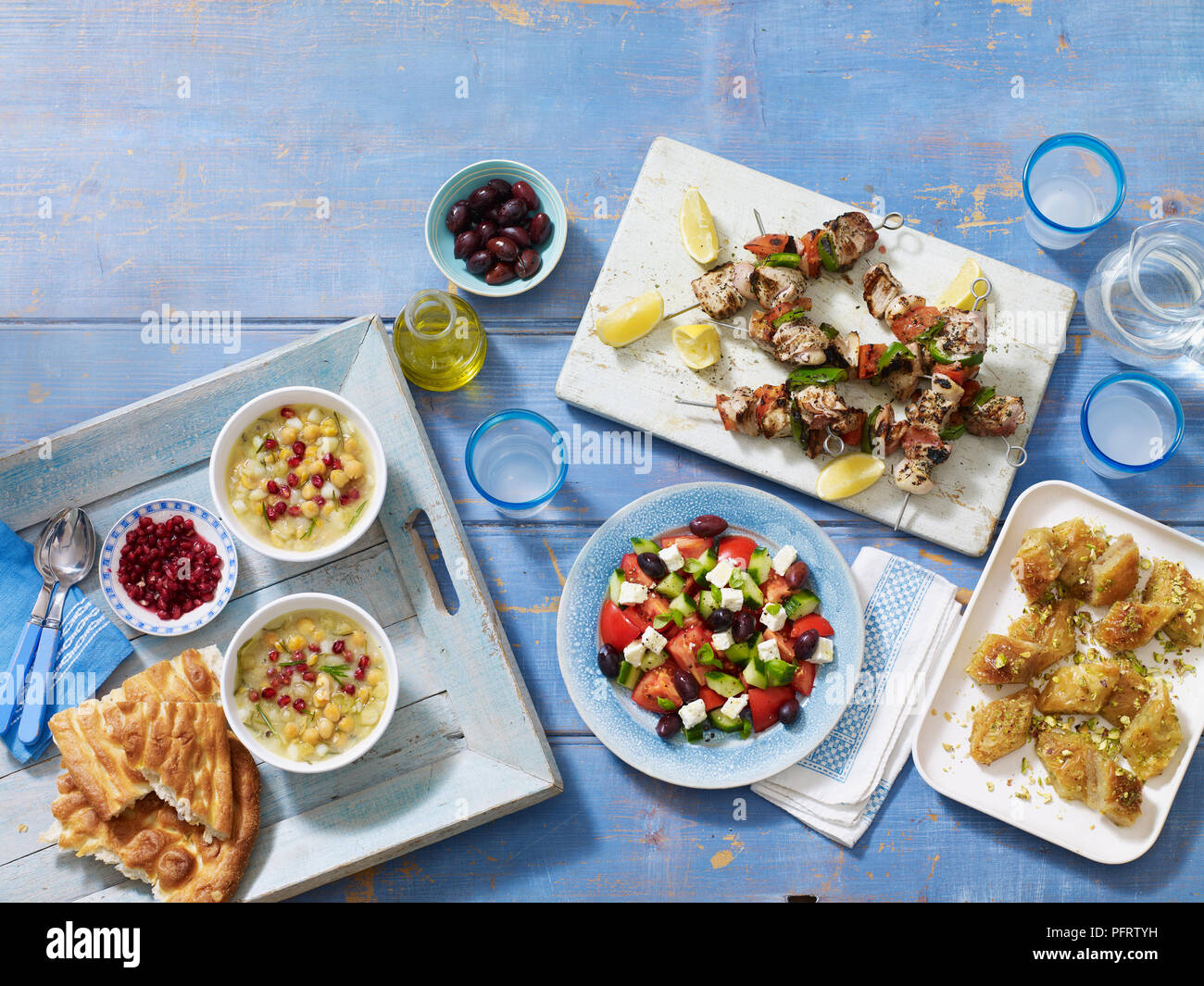 Griechische Mahlzeit, einschließlich revithosoupa (kichererbsen Suppe), kalamata Oliven, souvlakia, horiatiki Salata (Griechischer Salat), Baklava, Ouzo Stockfoto