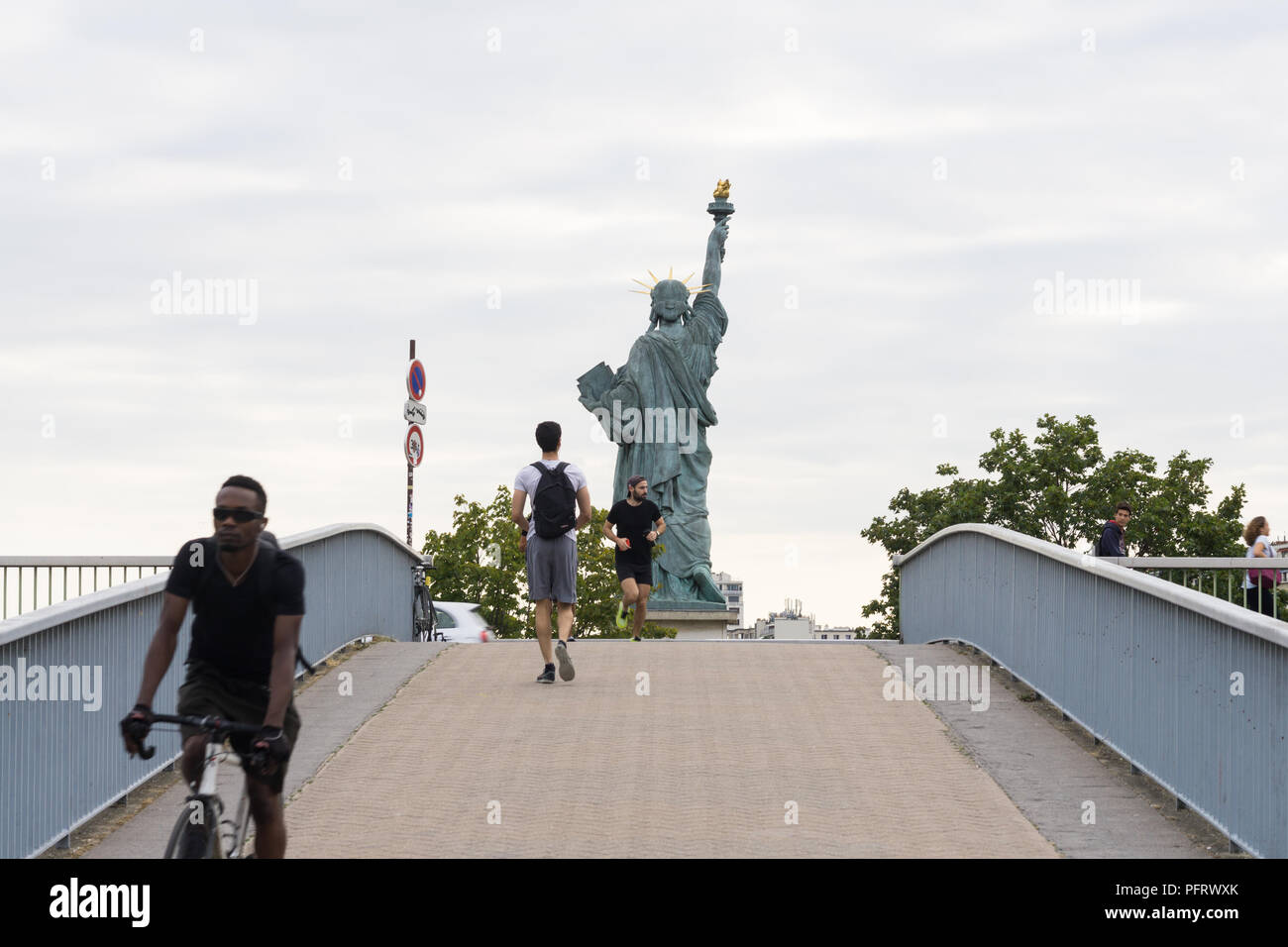 Paris Street Scene - eine Szene auf Pont de Grenelle - Männer vorbei an der Freiheitsstatue in Paris, Frankreich, Europa. Stockfoto
