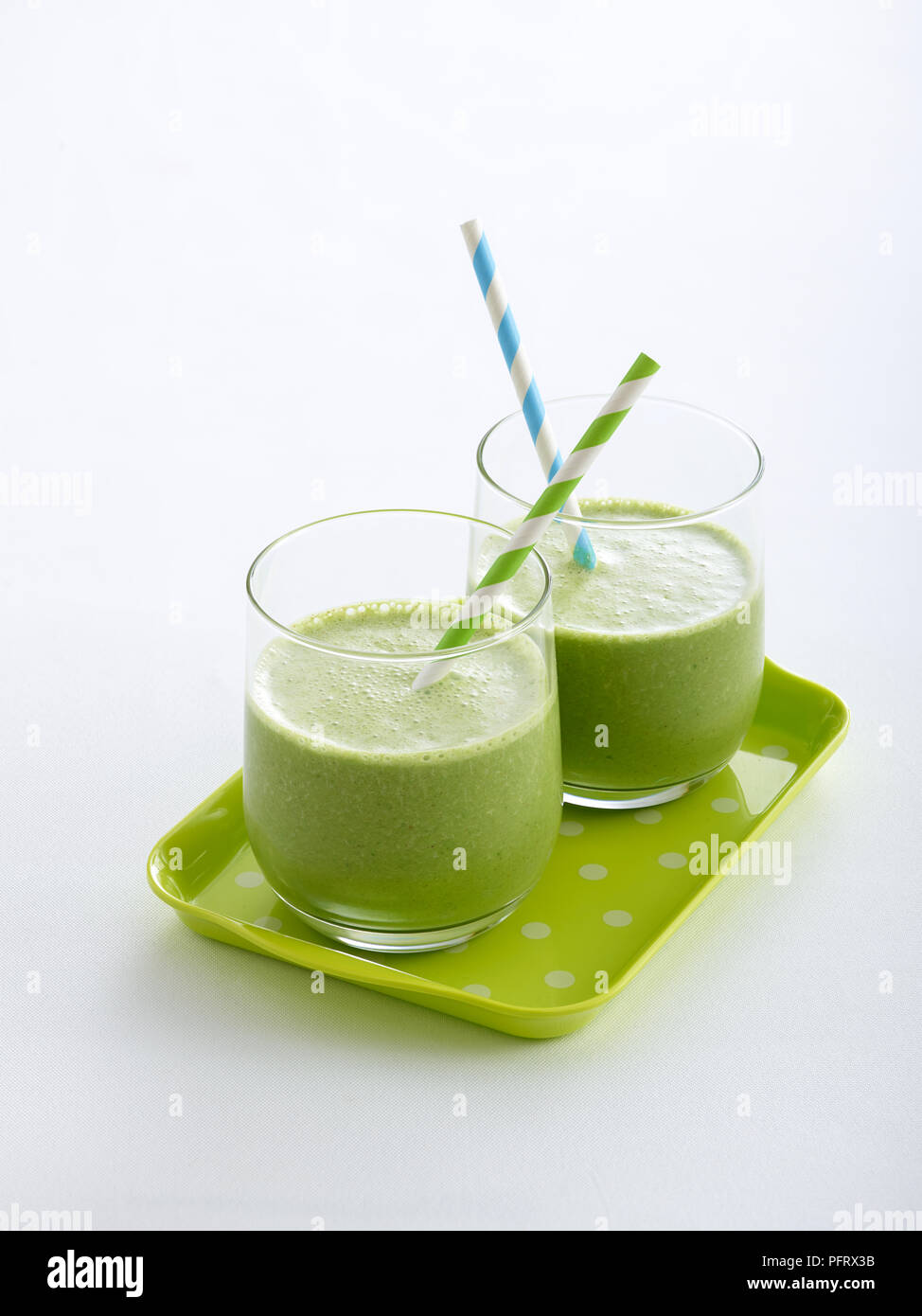 Zwei Gläser mit einem grünen Smoothies gefüllt, serviert auf einem grauen Fach Stockfoto