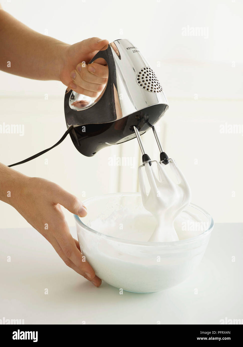 Baked Alaska, Eis, Schritt für Schritt. Den Eischnee schlagen, bis sie steif Spitzen Form. Stockfoto