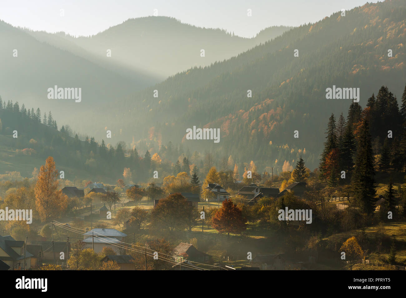 Farbenprächtige Herbstlandschaft im Bergdorf. Nebeliger morgen in den Karpaten, Ukraine Stockfoto