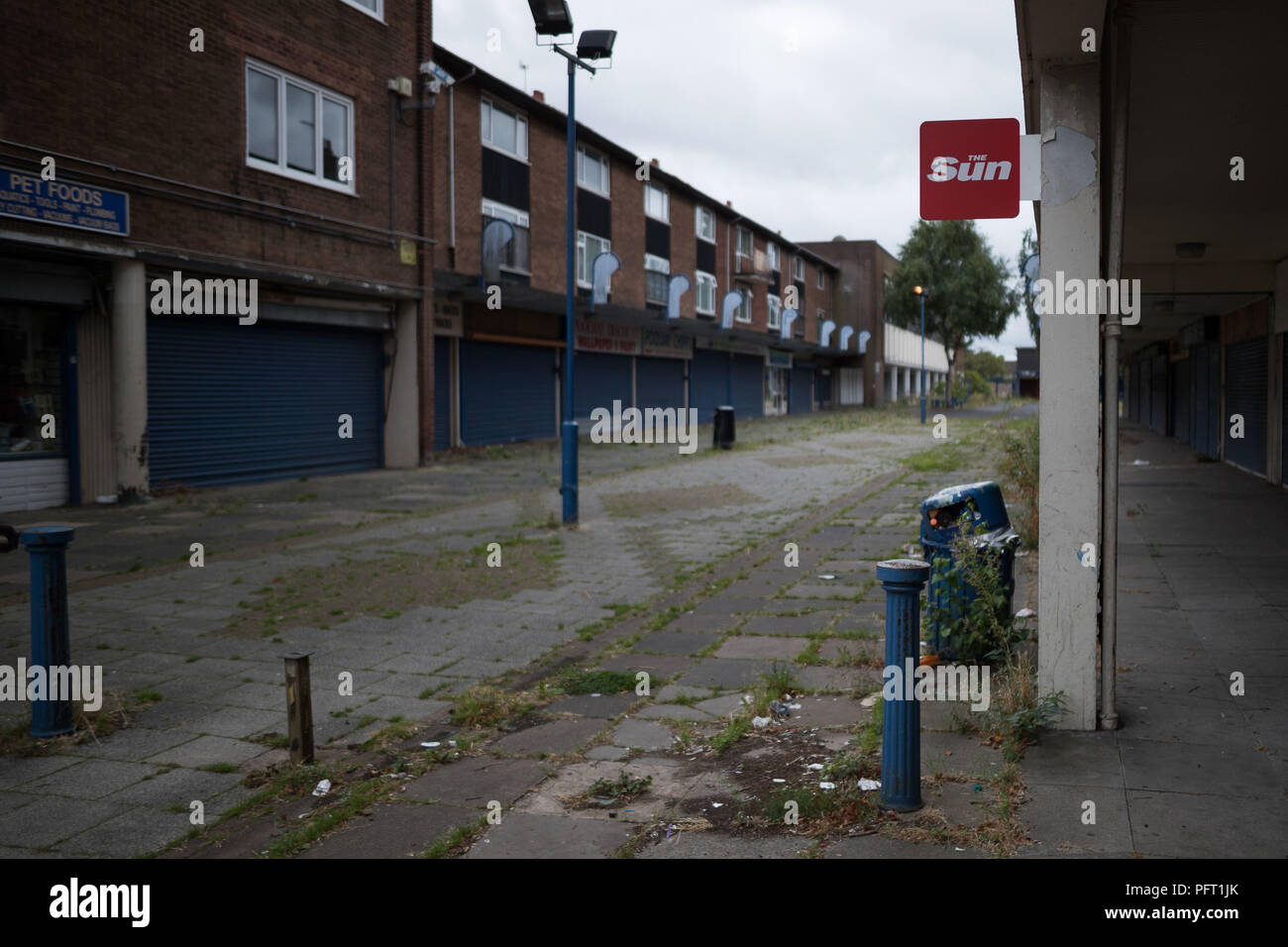 Unkraut vor geschlossene Geschäfte in das verlassene Poolway Einkaufszentrum in Garretts Green, Birmingham. 1961 errichtet, es war einst ein blühendes Handelszentrum mit lokalen und grossen Marke Geschäfte, hat aber eine Geisterstadt geworden, nur einige Monate nach dem Schließen. Stockfoto