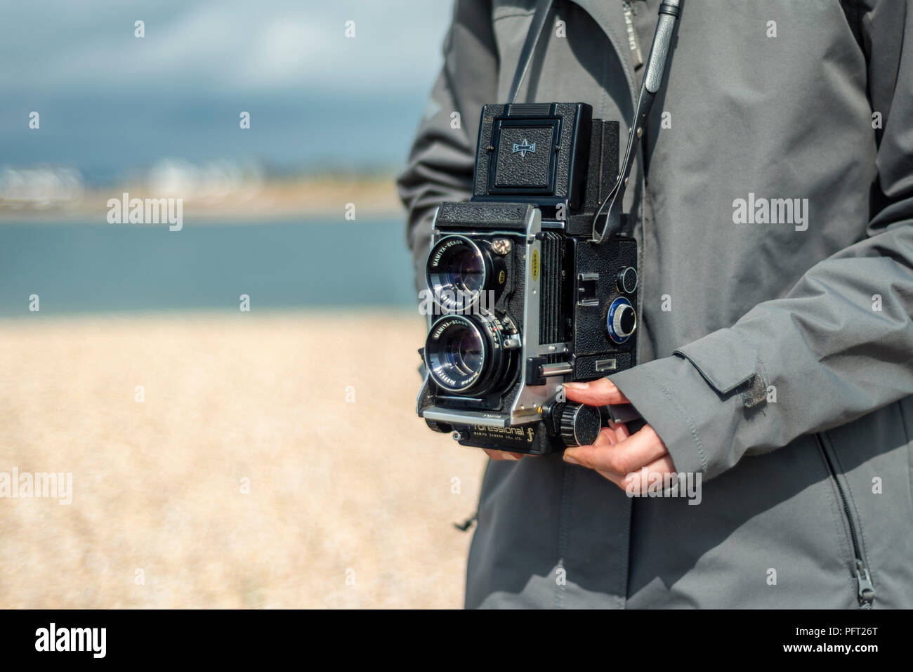 Person, die einen Retro twin lens reflex Kamera. Close Up, Taille. Stockfoto