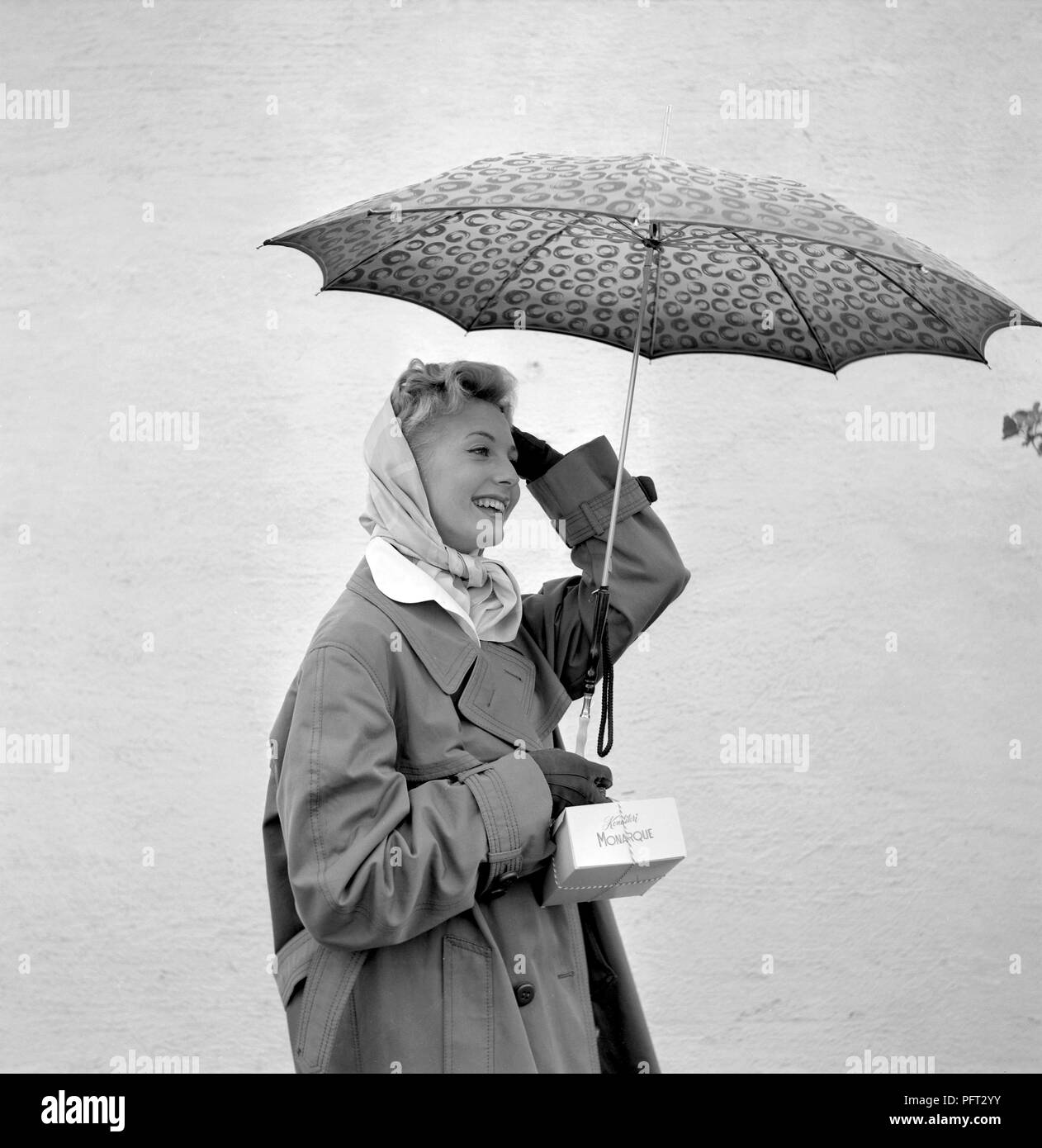 1950 Frau mit Regenschirm. Eine junge Frau hält einen Sonnenschirm an einem regnerischen Tag. Schweden 1955 Stockfoto