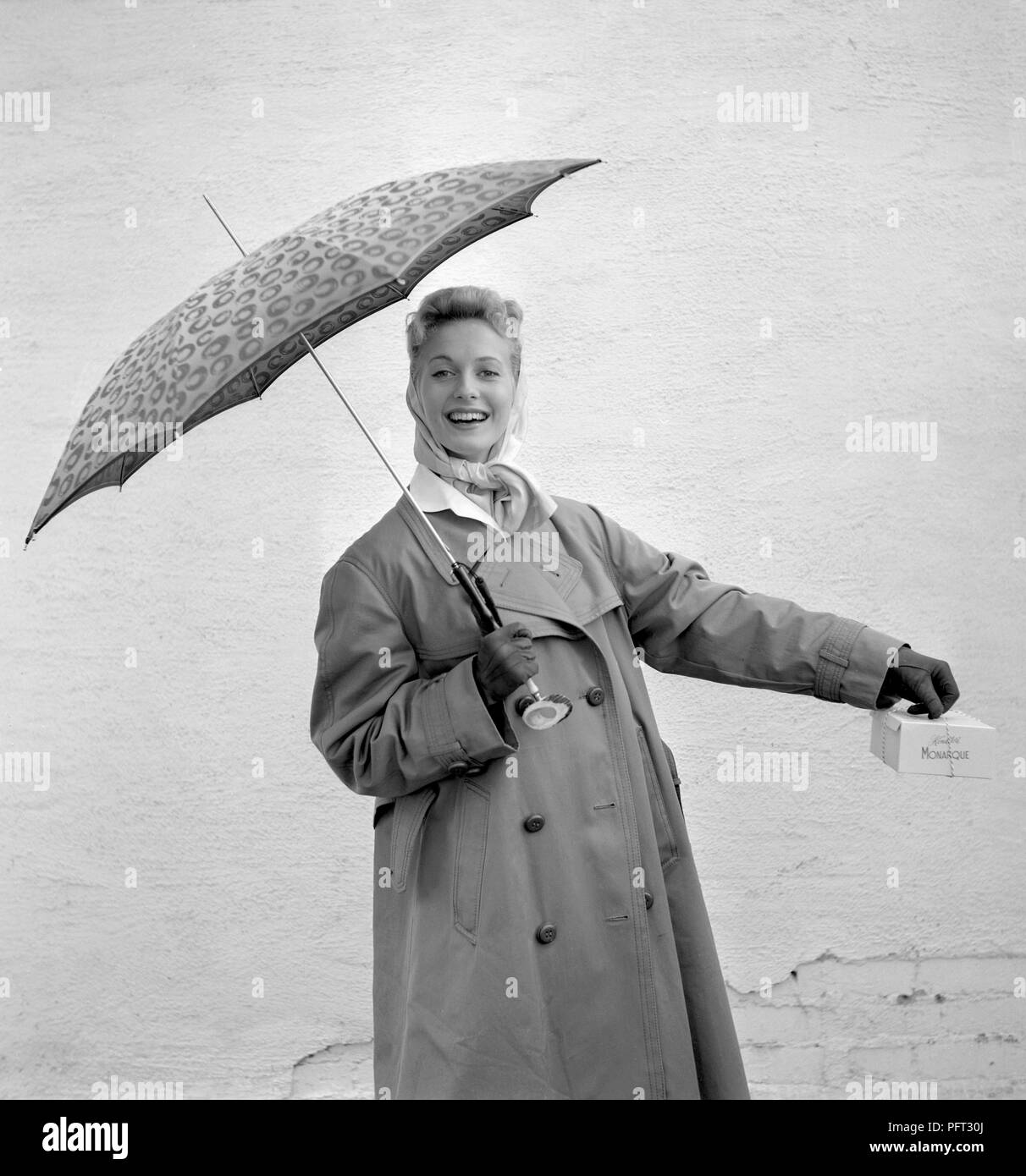 1950 Frau mit Regenschirm. Eine junge Frau hält einen Sonnenschirm an einem regnerischen Tag. Schweden 1955 Stockfoto