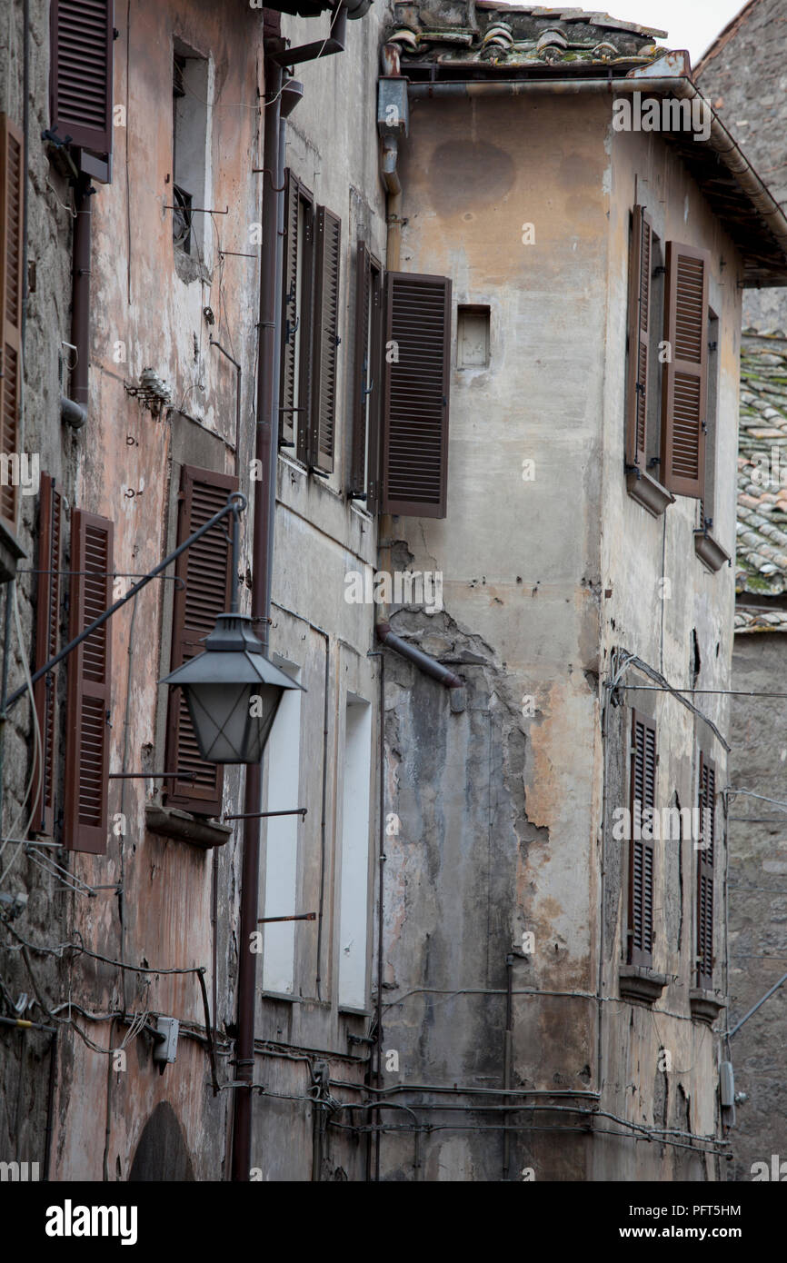 Italien, Latium, Provinz Viterbo, alte Gebäude mit braunen Fensterläden und Straßenlaterne in Stadt Stockfoto