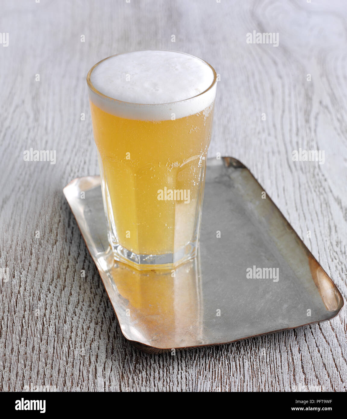 Glas Weißbier auf Fach Stockfoto