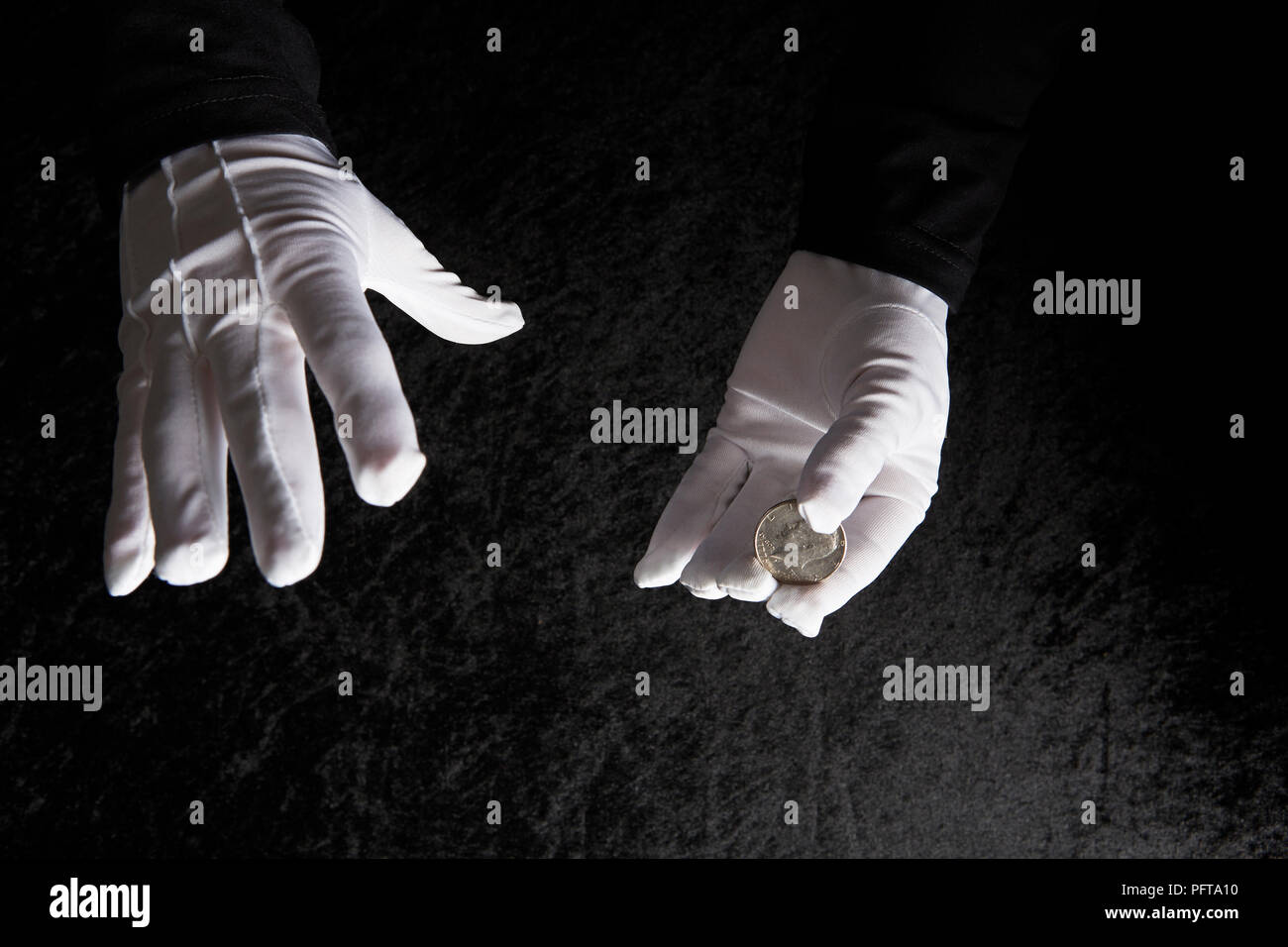 Weiß behandschuhten Hände halten Münze Stockfoto