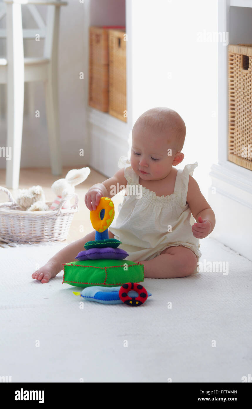 Baby Junge spielt mit Stapeln Spielzeug (Ring Spielzeug), 10,5 Monaten Stockfoto