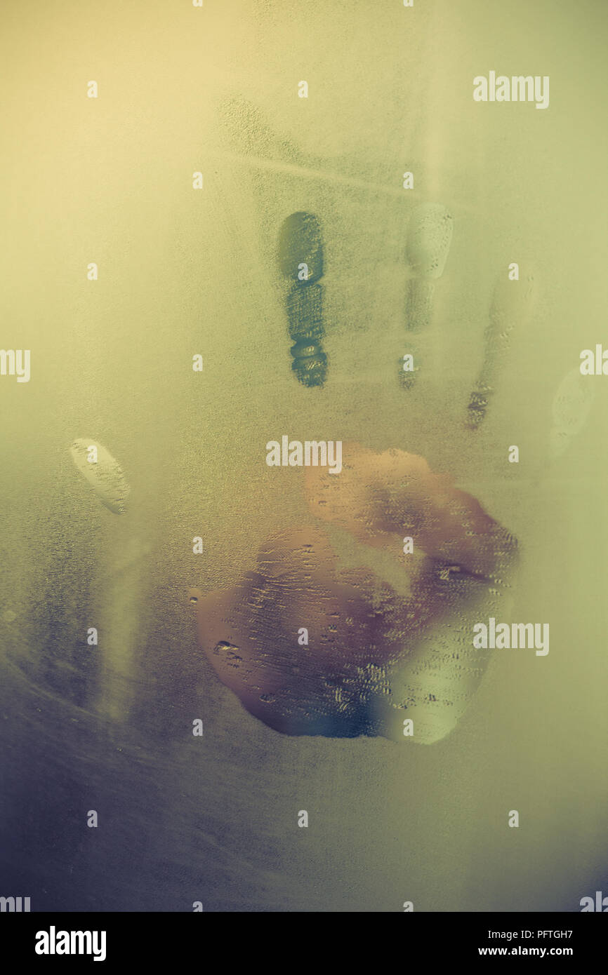 Handabdruck auf einem steamy Fenster und verschwommene Gesicht im Hintergrund Stockfoto