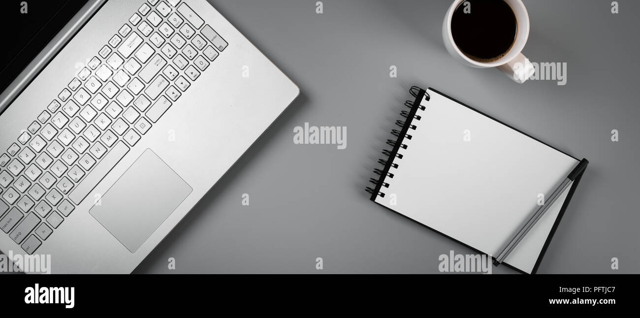 Schreibtisch mit Laptop, Kaffee und leer Notebook. top View Stockfoto