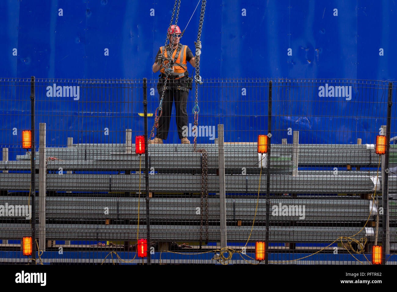 Ein Bauarbeiter überwacht das Anheben mit Hilfe eines Krans Fußboden neu in die oberen Stockwerken an der neuen Entwicklung hohe Bebauung bei 22 Bishopsgate in London City - der Capital District, am 21. August 2018 in London, England. 22 Bishopsgate ist ein kommerzielles Wolkenkratzer im Bau in London, Vereinigtes Königreich. Es wird ein prominenter Ort auf Bishopsgate besetzen, in der City von London Financial District, und ist 278 m hoch mit 62 Geschichten zu stehen. Das Projekt ersetzt eine frühere Plan für einen 288 m hohen Turm mit dem Namen Pinnacle, auf dem Bau im Jahr 2008 begonnen wurde, aber sus Stockfoto