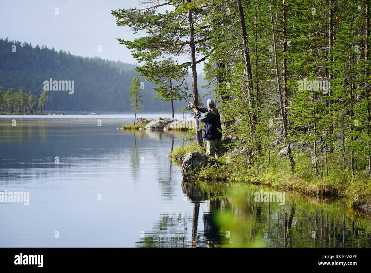 Mann Angeln am See in Lappland, Finnland Stockfoto