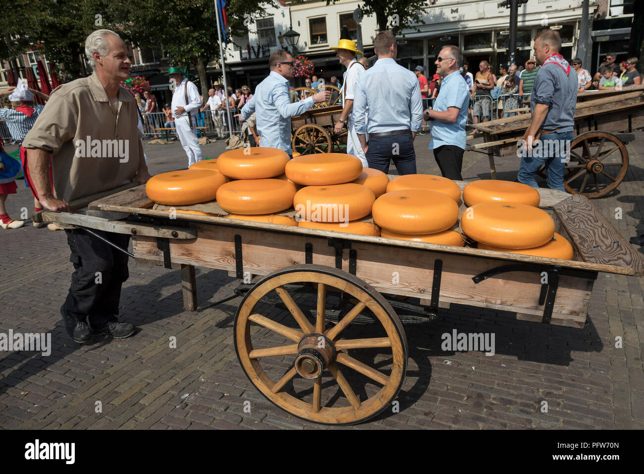 Alkmaar, Niederlande - 20 Juli, 2018: Die Menschen schieben eines traditionellen Holz- Warenkorb mit Käse Räder geladen, nachdem sie an den Käse verkauft beiing in Alkmaa Stockfoto