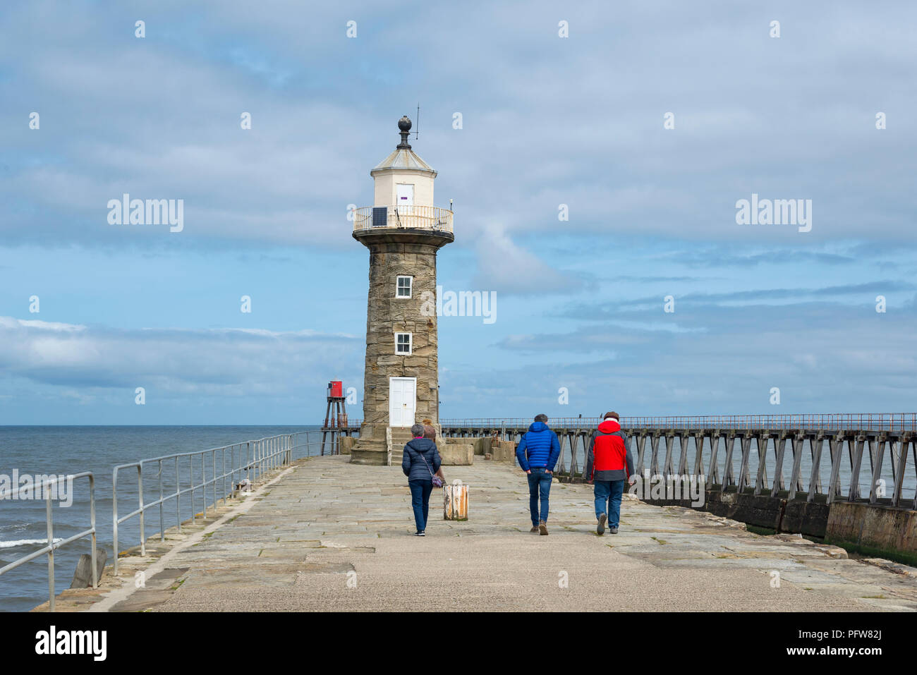 Familie einen Spaziergang entlang der Osten Pier in Whitby an der Küste von North Yorkshire, England. Stockfoto