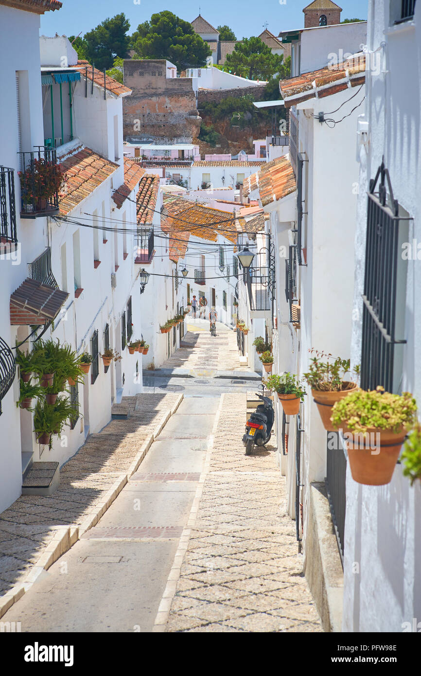 Radfahrer am Ende einer schmalen, steilen traditionelle Straße von der hübschen weißen gemauerten Häuser in Mijas, Andalusien Spanien Stockfoto
