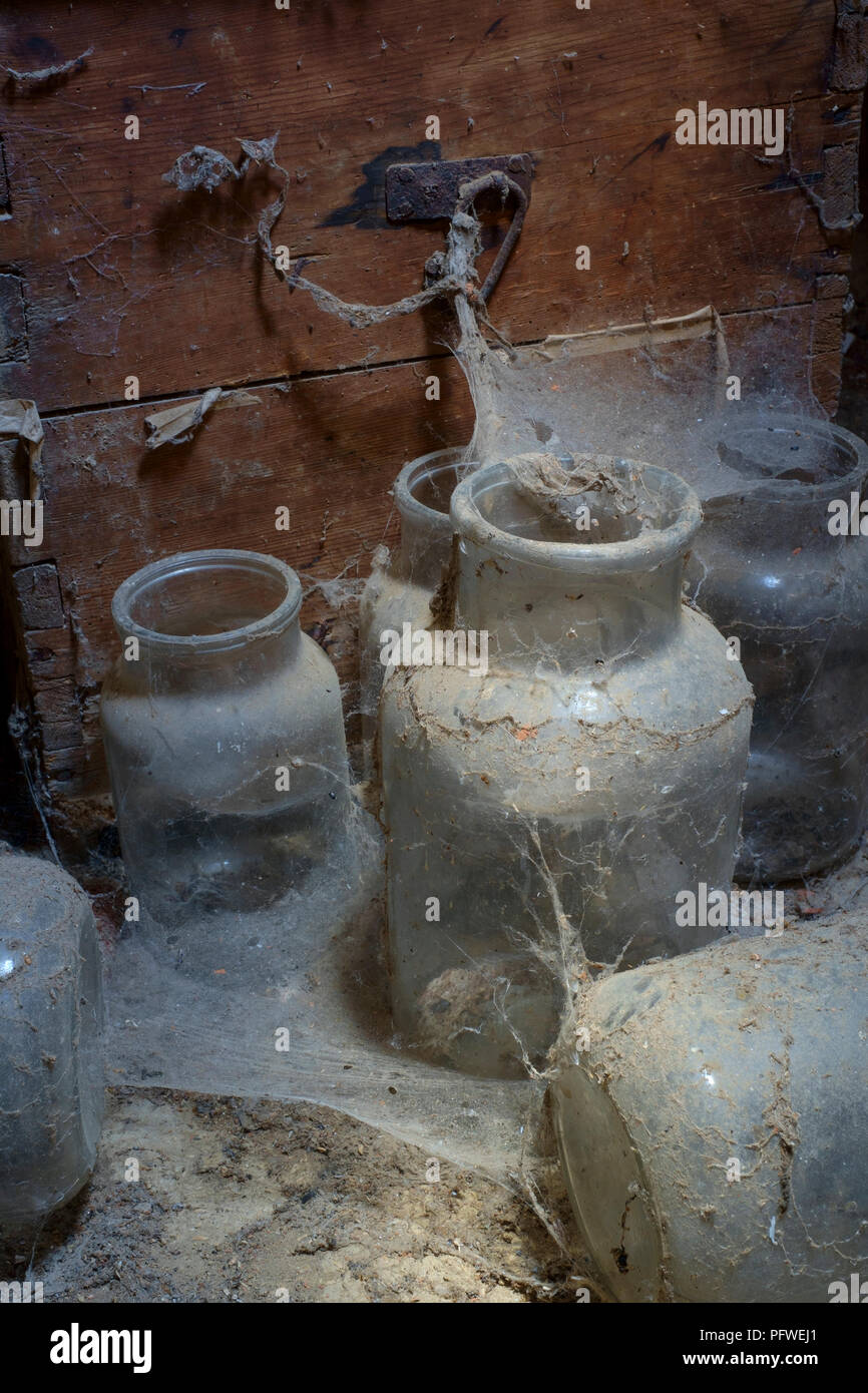 Alte Gläser und Holzkiste im Staub und Spinnweben in einem alten Bauernhaus im Dachgeschoss zala Ungarn ungestört und vergessen Festlegung abgedeckt Stockfoto
