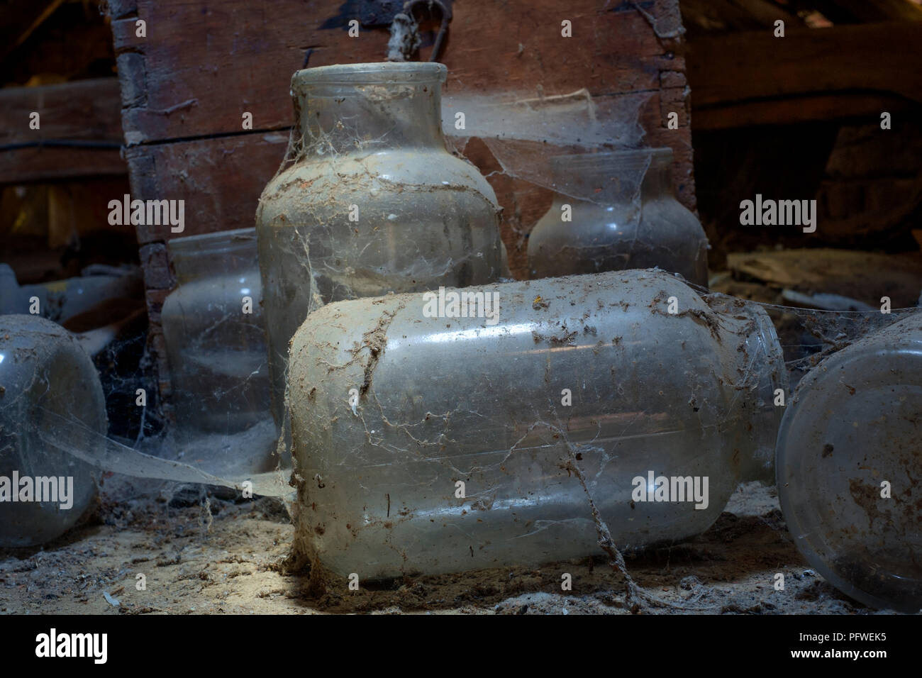 Alte Gläser und Holzkiste im Staub und Spinnweben in einem alten Bauernhaus im Dachgeschoss zala Ungarn ungestört und vergessen Festlegung abgedeckt Stockfoto