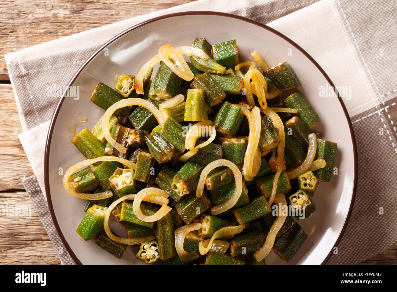 Herzhafte Speisen grün Okra mit Zwiebel close-up auf einem Teller auf den Tisch. horizontal oben Ansicht von oben, rustikal Stockfoto
