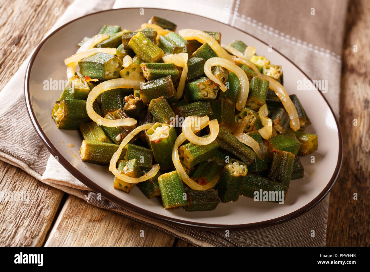Herzhafte Speisen grün Okra mit Zwiebel close-up auf einem Teller auf den Tisch. Horizontale, rustikal Stockfoto
